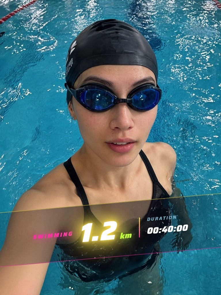 A swimmer in goggles at the lane rope, with SWIMMING 1.2 km and a duration of 00:40:00 across a neon band